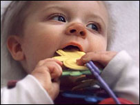 Baby with rattle in cot