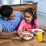 Happy Father Having Breakfast With His Daughter In The Kitchen