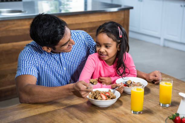 Happy Father Having Breakfast With His Daughter In The Kitchen
